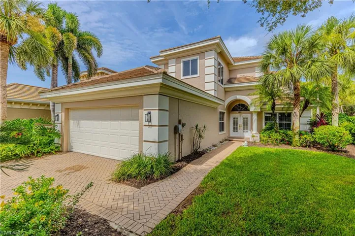 Mediterranean / spanish-style home featuring french doors, stucco siding, decorative driveway, a front yard, and a garage