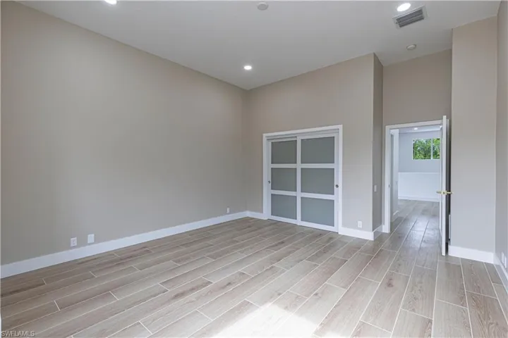 Empty room featuring light wood-type flooring and recessed lighting