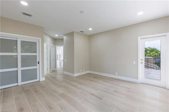 Spare room featuring light wood-style flooring and recessed lighting & Private balcony with water view
