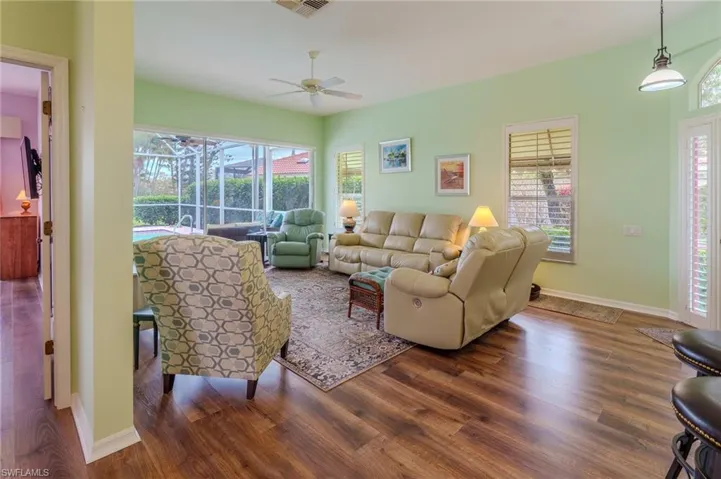 Living area featuring wood finished floors, plenty of natural light, a ceiling fan, and a sunroom