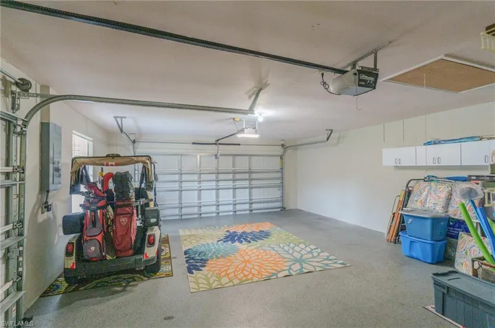 Garage featuring a garage door opener and electric panel