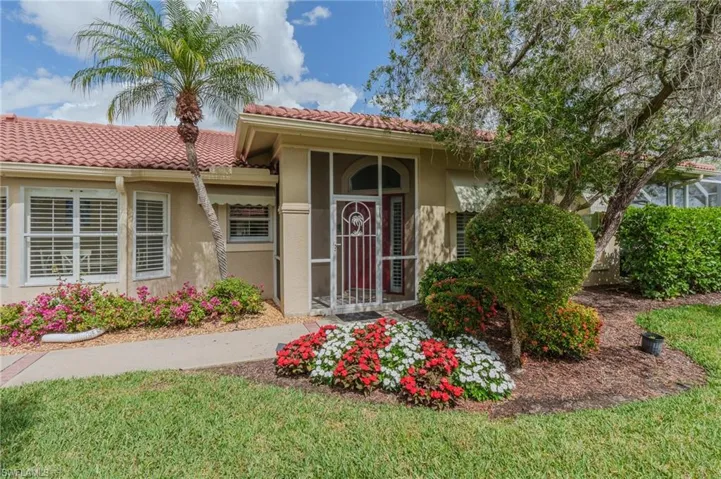 Entrance to property featuring stucco siding, a yard, and a tiled roof