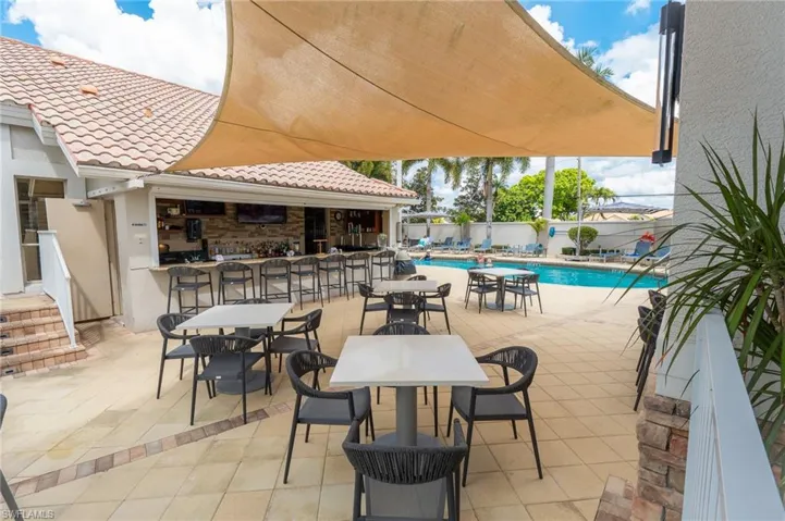 View of patio with a bar and a community pool