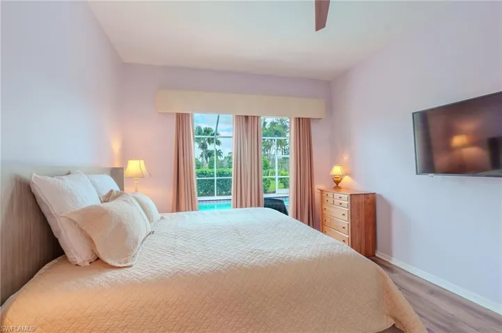 Bedroom with wood finished floors, ceiling fan, and access to exterior