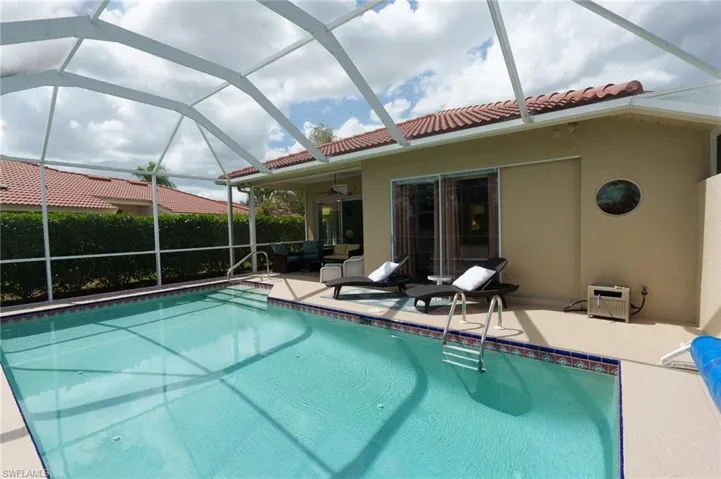 View of pool featuring a lanai, a sunroom, and patio surround