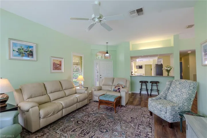Living room featuring ceiling fan and dark wood-style flooring