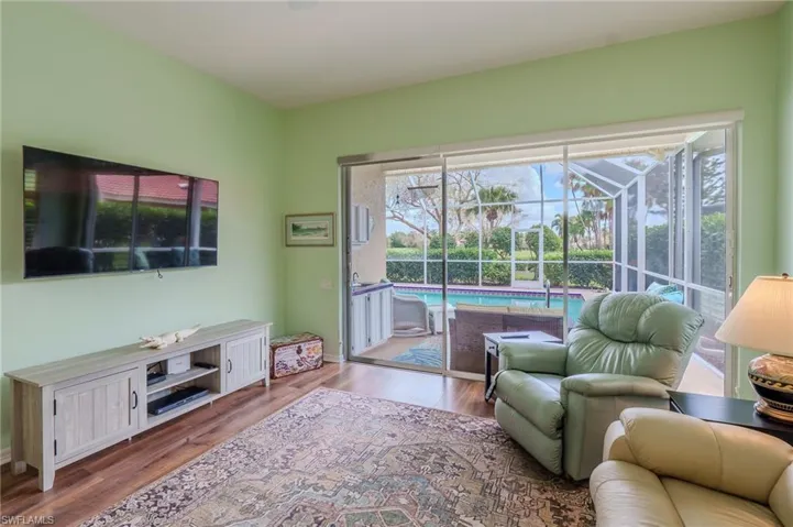 Living area with wood finished floors, healthy amount of natural light, and a sunroom