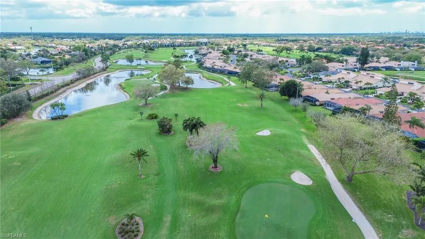 View of property location with nearby suburban area, a local golf course, and a nearby body of water