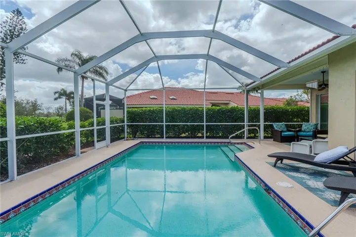 Swimming pool featuring a sunroom, glass enclosure, and a patio