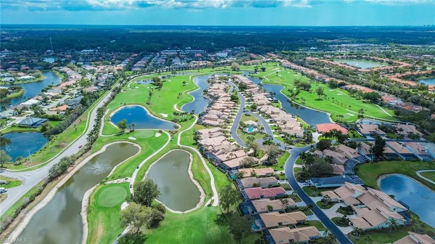Aerial view of property's location featuring nearby suburban area, a local golf course, and a large body of water
