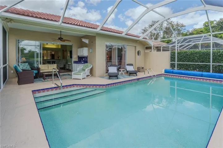 View of pool featuring a covered pool, a sunroom, and glass enclosure