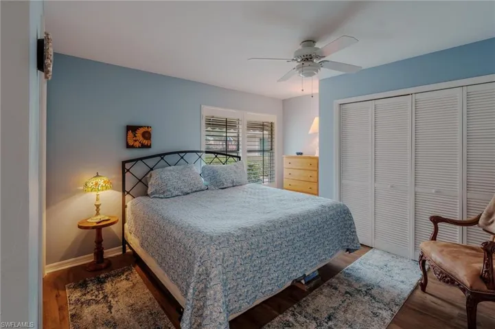 Bedroom featuring wood finished floors, a closet, and a ceiling fan