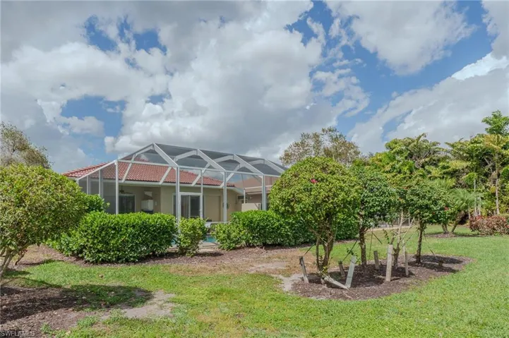Back of property featuring a lanai, a sunroom, and a yard