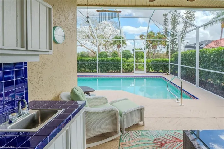 Swimming pool featuring a sunroom, a patio area, and a lanai