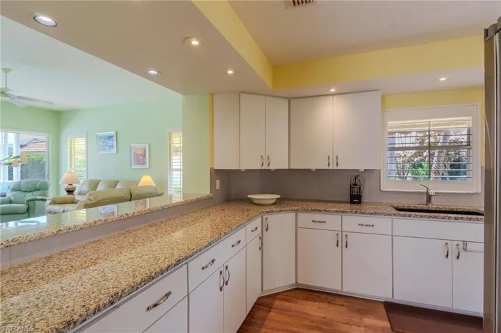 Kitchen featuring recessed lighting, light stone countertops, light wood-style flooring, ceiling fan, and backsplash