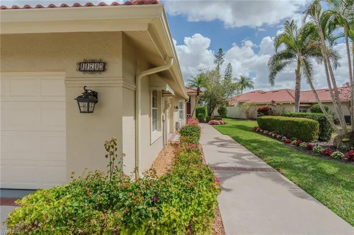 View of side of property featuring a yard, stucco siding, and an attached garage