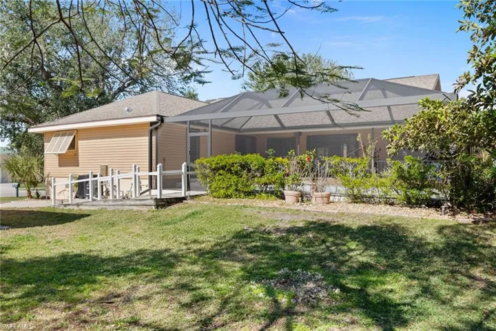 Rear view of property with a lawn and glass enclosure