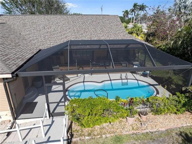 View of pool featuring a patio and glass enclosure
