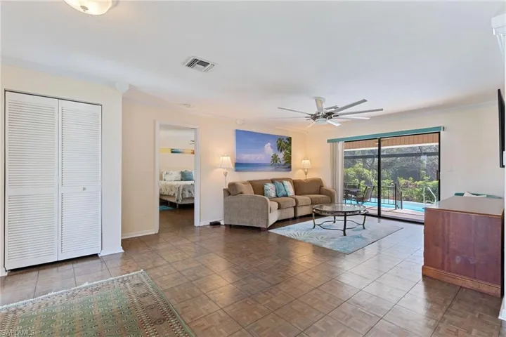 Living room featuring crown molding, parquet flooring, and ceiling fan