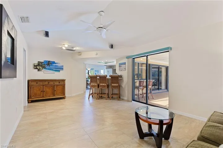 Living room with lofted ceiling and ceiling fan