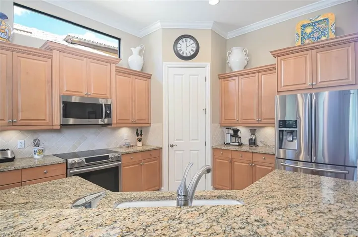 Kitchen with tasteful backsplash, appliances with stainless steel finishes