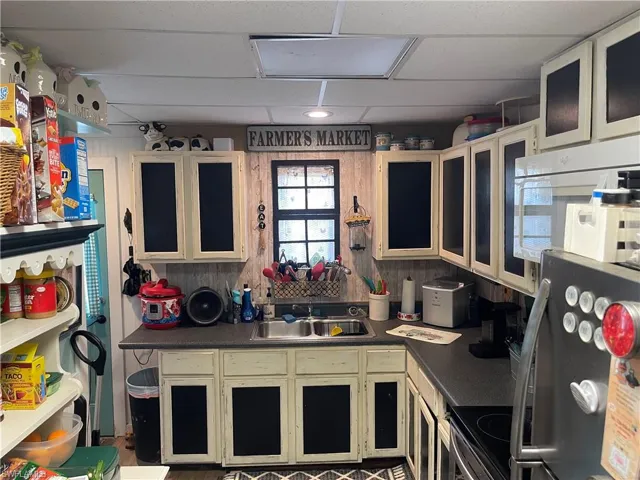 Kitchen featuring sink, hardwood / wood-style floors, stove, and a paneled ceiling