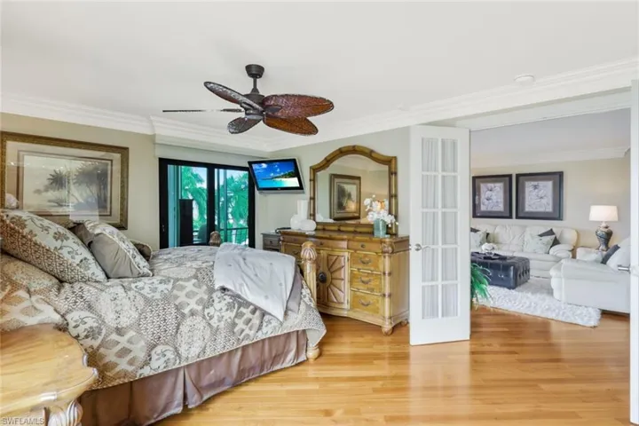 Bedroom featuring crown molding, light hardwood / wood-style flooring, ceiling fan, and access to outside