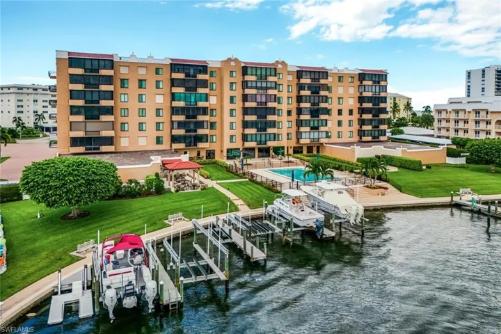 Dock area with a lawn, a community pool, and a water view