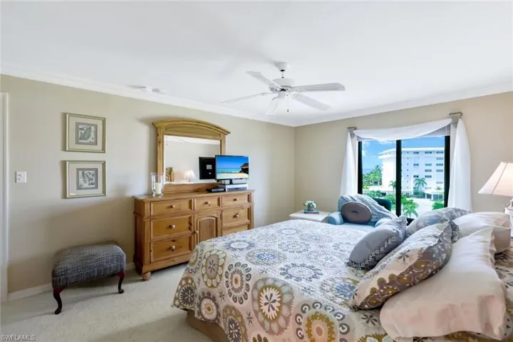 Bedroom with ceiling fan, ornamental molding, light carpet, and access to outside