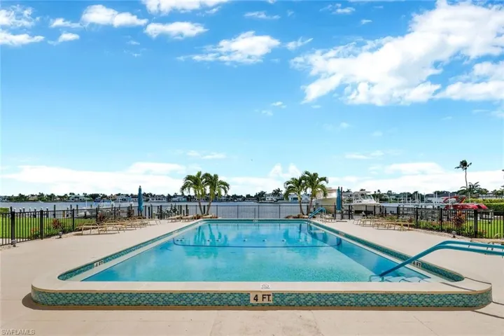 View of swimming pool with a water view and a patio area