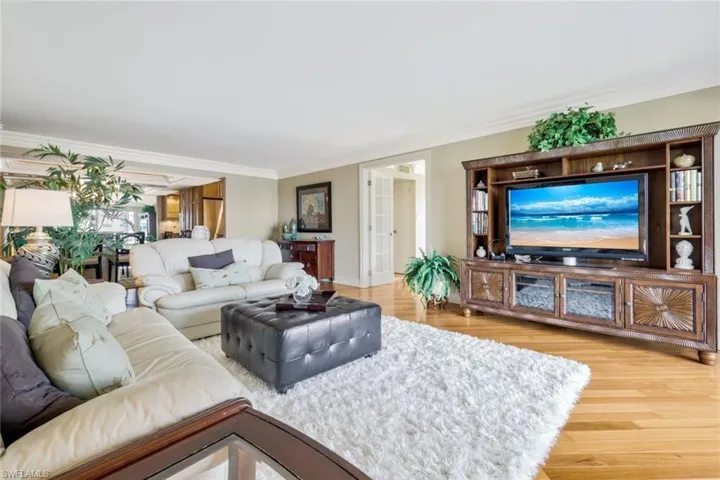 Living room with ornamental molding and hardwood / wood-style flooring