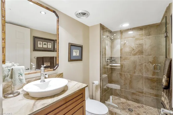 Bathroom with vanity, toilet, and an enclosed shower