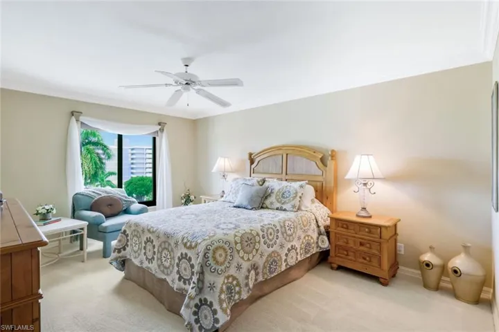 Carpeted bedroom with crown molding and ceiling fan