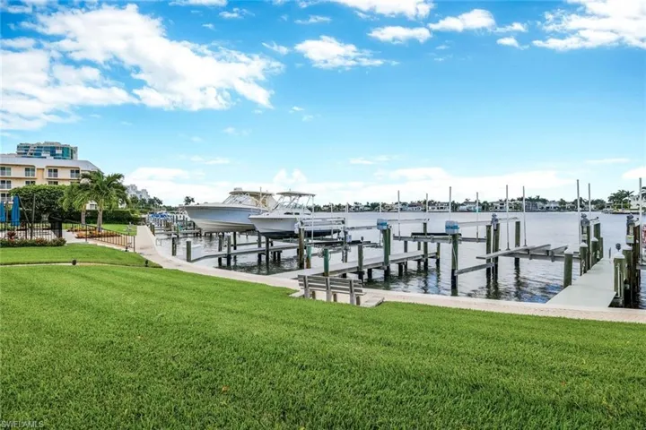 Dock area featuring a water view and a lawn
