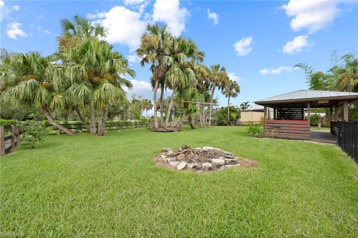 Fenced backyard featuring an outdoor fire pit, a gazebo, and a patio