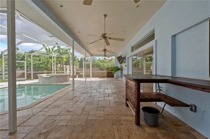 View of swimming pool with a patio area, glass enclosure, a sunroom, and ceiling fan