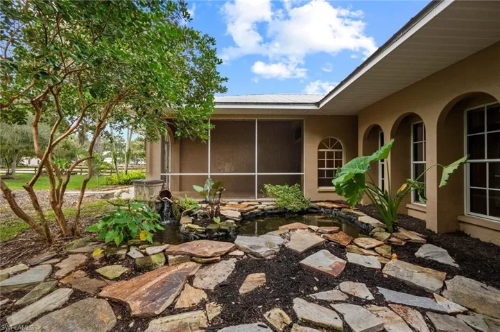 View of patio / terrace with a small pond and a sunroom