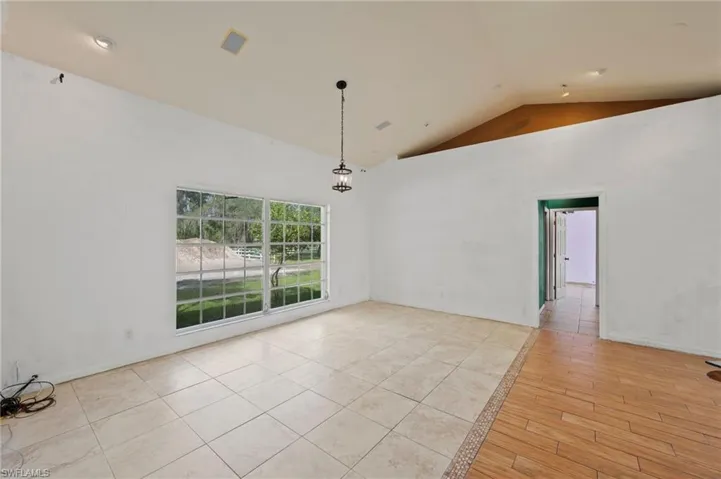 Unfurnished room featuring high vaulted ceiling and light wood-type flooring