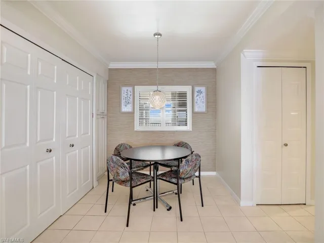 Dining area featuring a notable chandelier, light tile patterned floors, and crown molding