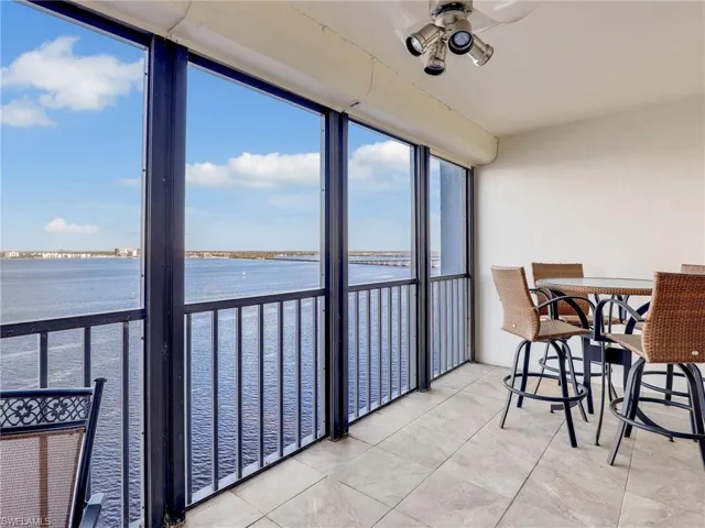 Sunroom / solarium featuring ceiling fan and a water view