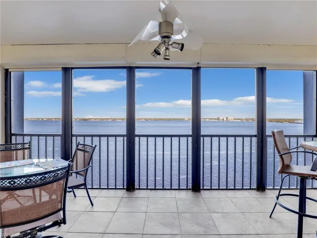 Sunroom / solarium with a water view and ceiling fan