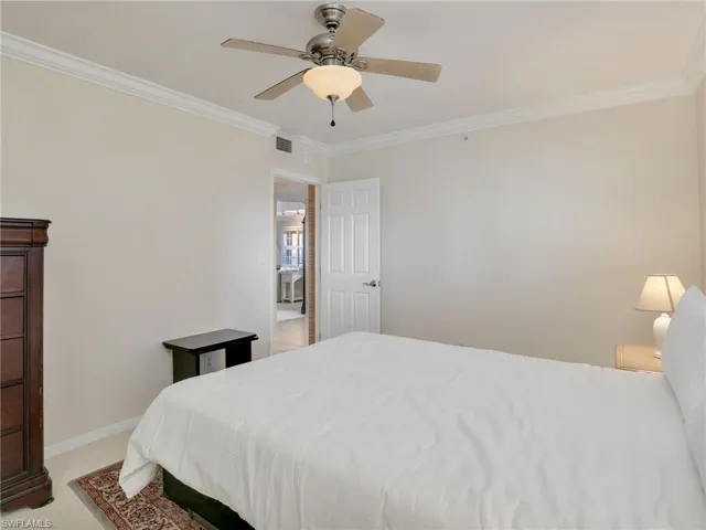 Carpeted bedroom with ornamental molding and ceiling fan