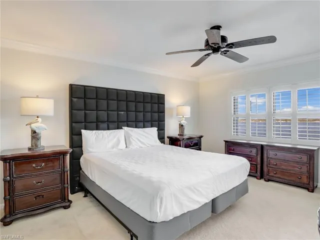 Bedroom featuring ceiling fan, crown molding, and light colored carpet