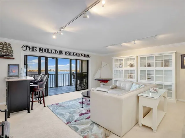 Living room featuring light carpet and a water view