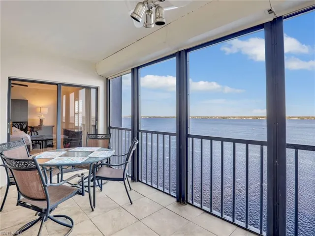Sunroom featuring ceiling fan and a water view