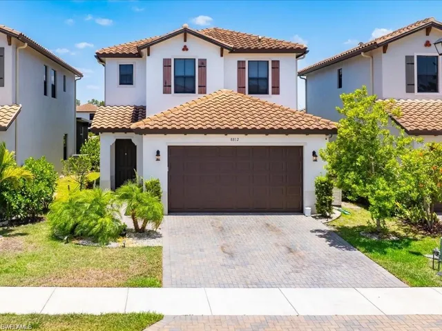 Mediterranean / spanish-style house with stucco siding, driveway, an attached garage, and a tiled roof
