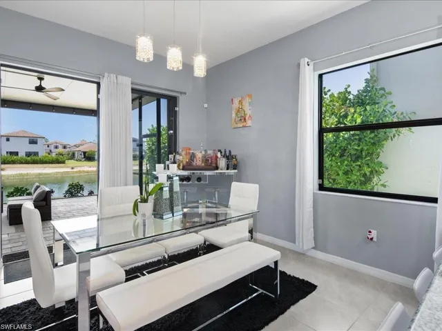 Dining room with ceiling fan, light tile patterned floors, and a water view