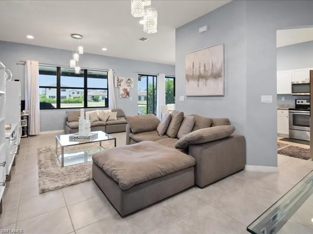 Living area featuring light tile patterned floors, a chandelier, and recessed lighting