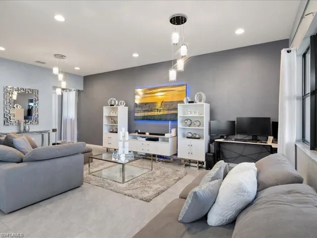 Living room with a desk, recessed lighting, and tile patterned flooring
