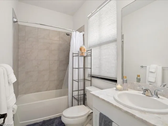 Bathroom with shower / bath combo with shower curtain and vanity